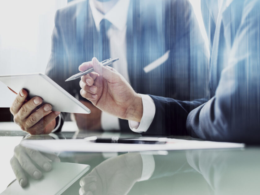 Corporate businessmen working on tablet at office